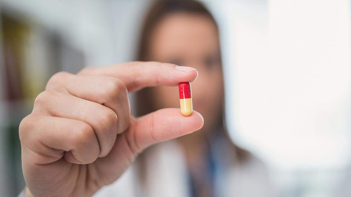 Female doctor holding a pill pharmacist pharmacy drug prices medication medicine