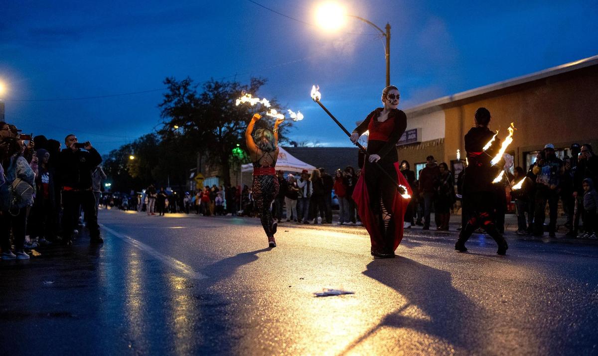 Fire artists perform during the Dia de los Muertos parade hosted by the Central Avenue Betterment Association on Saturday in Kansas City, Kan.