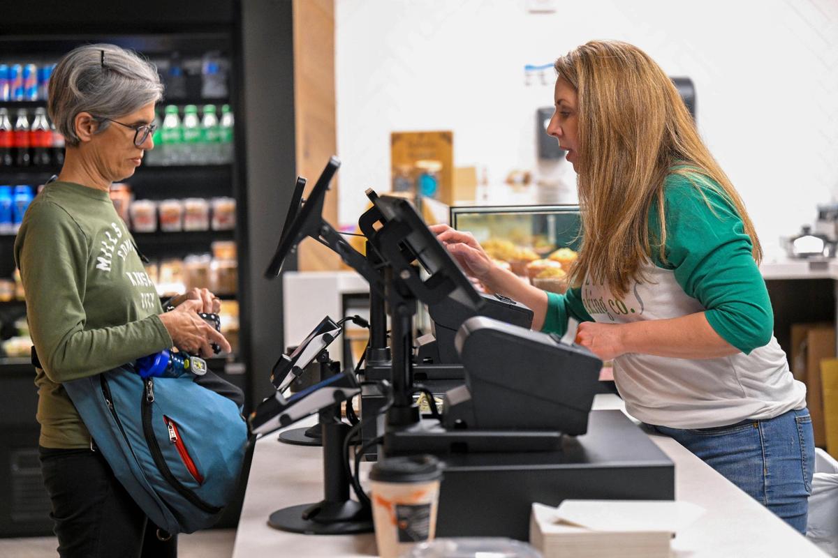 Sarah Darby, right, owner of Bloom Baking Co., rings up a customer on Wednesday at her location inside the new terminal at Kansas City International Airport.