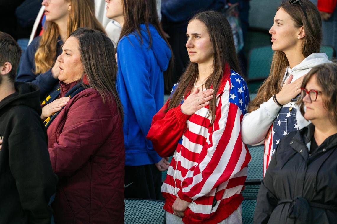 A fan wearing an American flag jacket holds her hand over her heart for the Pledge of Allegiance at the USA vs. Canada rugby match at CPKC Stadium on Friday, May 2, 2025. Canada won the match 26-14.