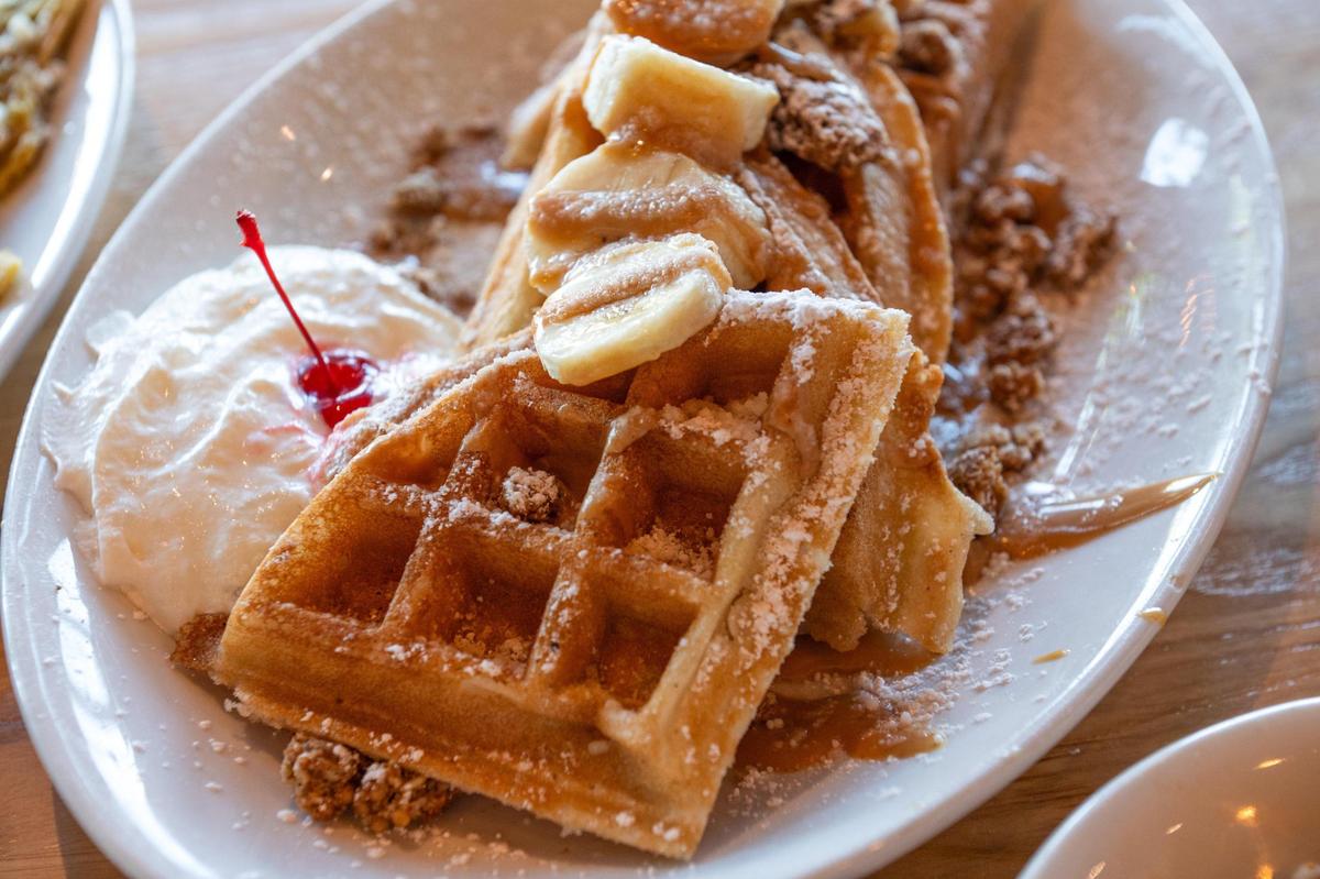 Bananas, a peanut butter drizzle, whipped cream and granola coat the Banana Monster Waffles at AR’s Breakfast & Brunch.