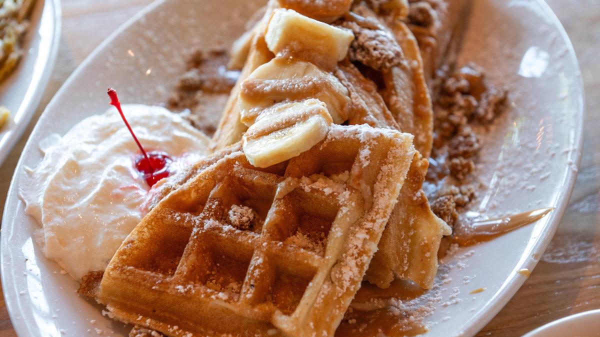 Bananas, a peanut butter drizzle, whipped cream and granola coat the Banana Monster Waffles at AR’s Breakfast & Brunch.
