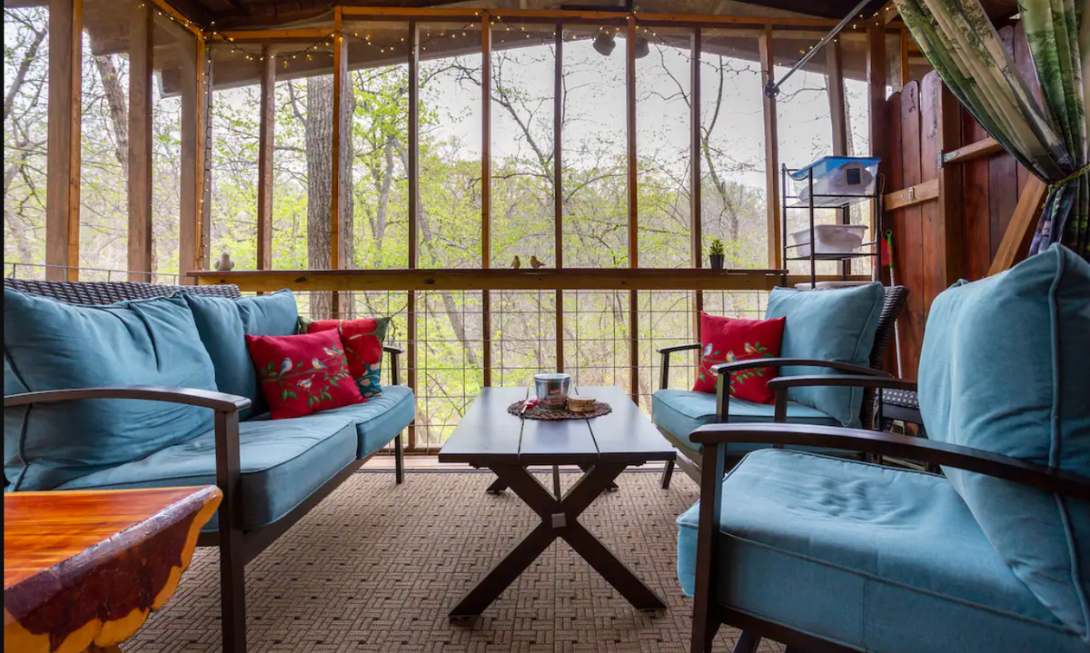 A screened-in porch inside Graham’s Treehouse overlooks the property’s trails and creeks.