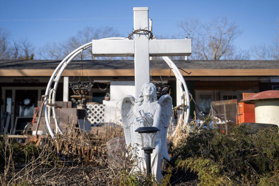 A cross bearing a crown of thorns and an angel statue sit outside the home of Damon B. Leonard, 47, in the Holiday Lakes area on Monday, Jan. 12, 2026, in Pleasanton, Kansas. 