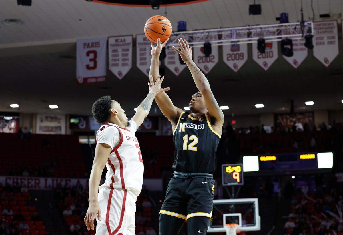 Missouri Tigers guard Tony Perkins, right, shoots over Oklahoma Sooners guard Brycen Goodine during an SEC men’s basketball game at the Lloyd Noble Center on Wednesday, March 5, 2025 in Norman, Okla.