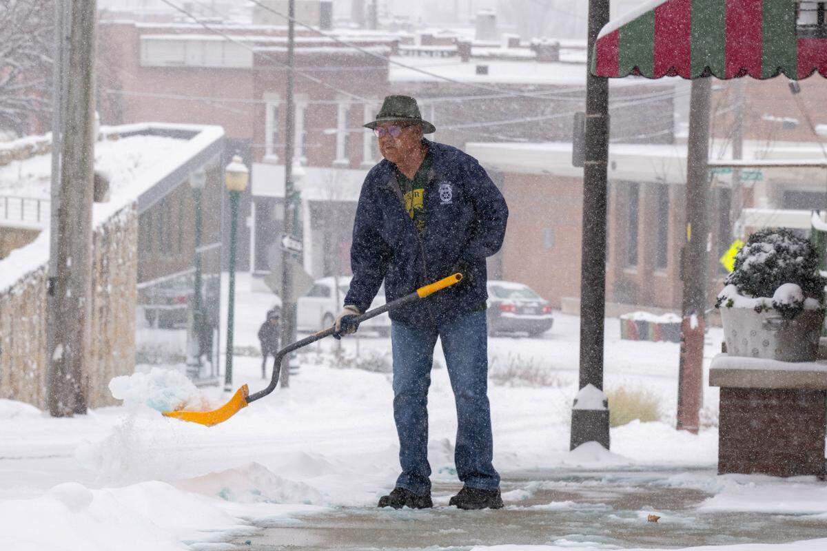 Pryde's Old Westport employee Jose Luis Rodriguez shovels snow as snow blanketed the Kansas City metro area on Monday. The areas expected to accumulate 3 to 5 inches.