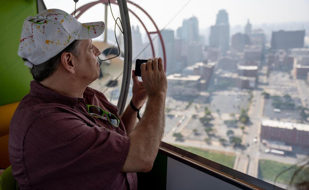 Mike Edson of Independence uses his phone to shoot photos of downtown Kansas City aboard the Subway blimp on Wednesday.