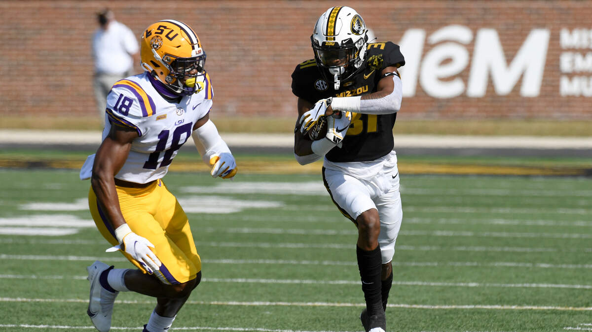 Missouri wide receiver D’ionte Smith, right, runs with the ball before being knocked out of bounds by LSU linebacker Damone Clark (18) during the first half of an NCAA college football game Saturday, Oct. 10, 2020, in Columbia, Mo. (AP Photo/L.G. Patterson)
