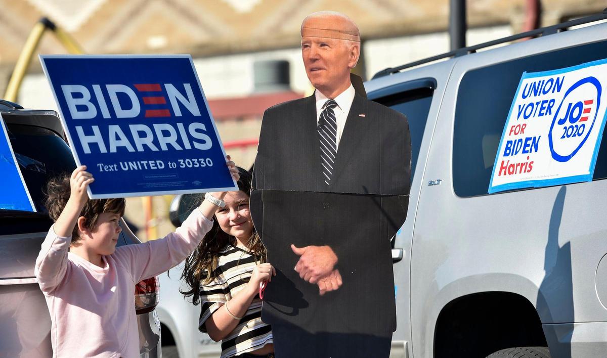 Nine-year-old friends Delaney Bindley, left, and Sophie Podhola get ready for a car parade to celebrate the presidential election victory of Joe Biden and Kamala Harris Saturday. The parade started at the Gregg/Klice Community Center near 18th and Vine.