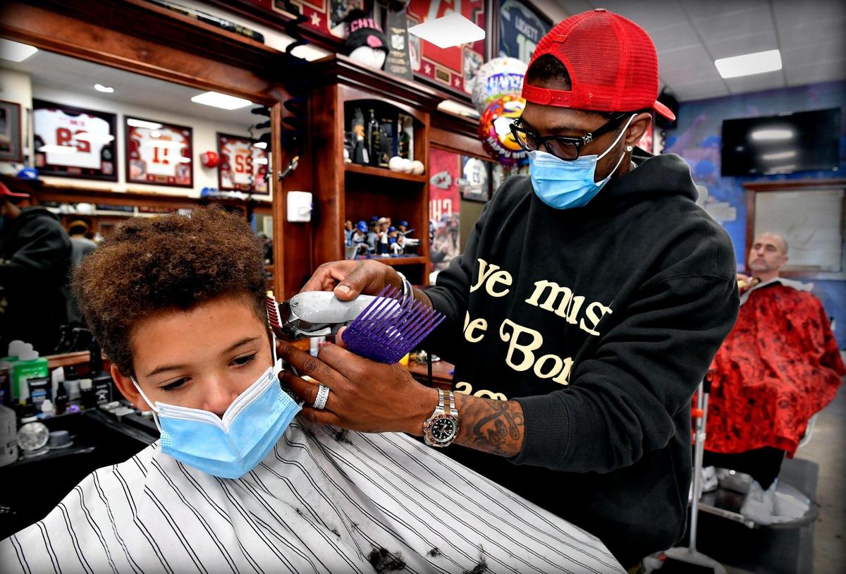 DeJuan Bonds gets a lot of requests for the Mahomes haircut, and for good reason — he’s Patrick Mahomes’ beloved barber. Here Bonds sculpts the locks of T.J. Releford, 9, of Kansas City, whose father, Travis Releford, played basketball for the University of Kansas.