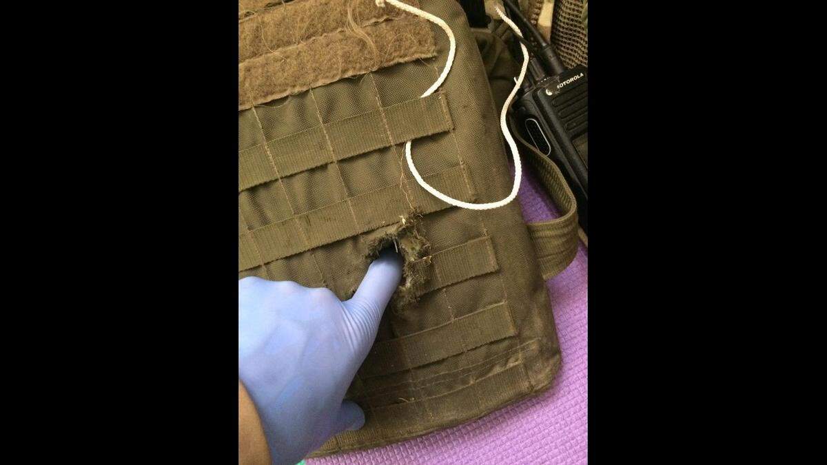 Artyom Semenyuk in Kyiv, shows the bulletproof vest of a friend in military brigade 3018 following gunfire from Russian troops.