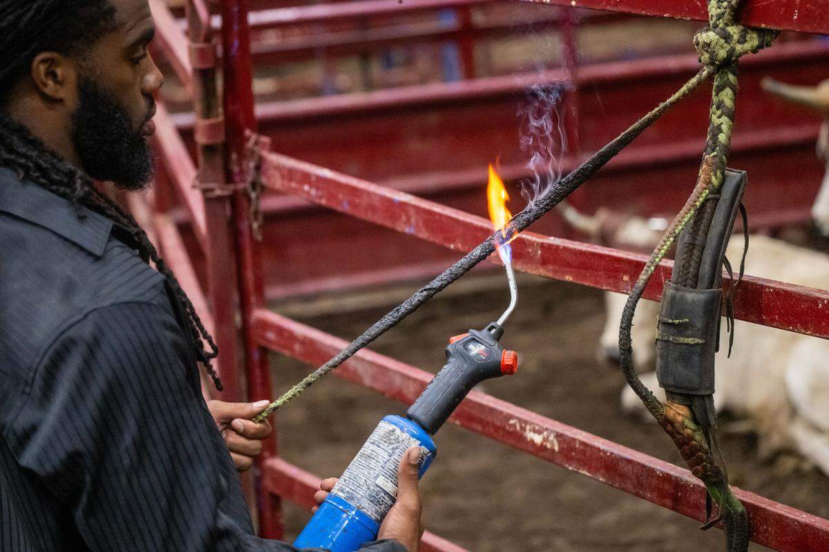 Au’Vion Horton of Hope, Arkansas preps his rope by burning it, prior to the bullriding event at the Black Rodeo USA show, inside the American Royal in Kansas City on Saturday, July 26, 2025. Burning the rope makes it stickier and easier to hold onto.