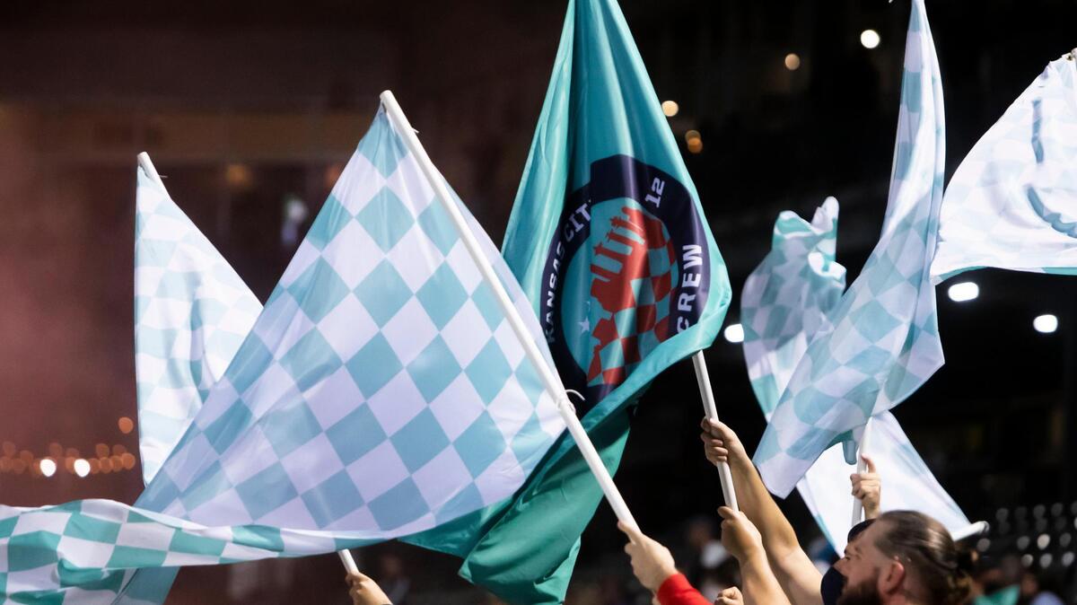 Supporters wave banners after the club’s win against the Houston Dash on Oct. 13 at Legends Field in Kansas City, Kan.