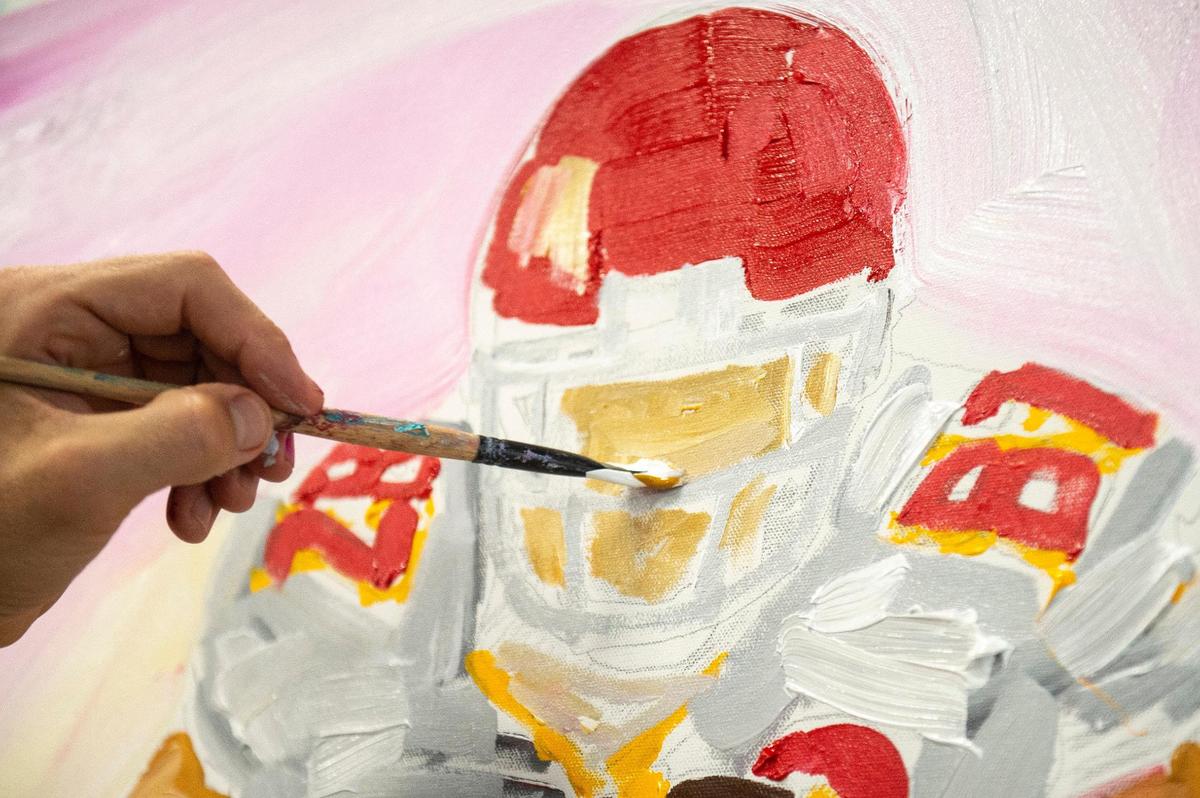 John Bukaty works on a painting of Travis Kelce running. He put together the painting in less than an hour while talking to The Star.