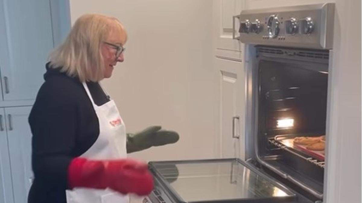 Donna Kelce pulling her homemade cookies out of the oven.