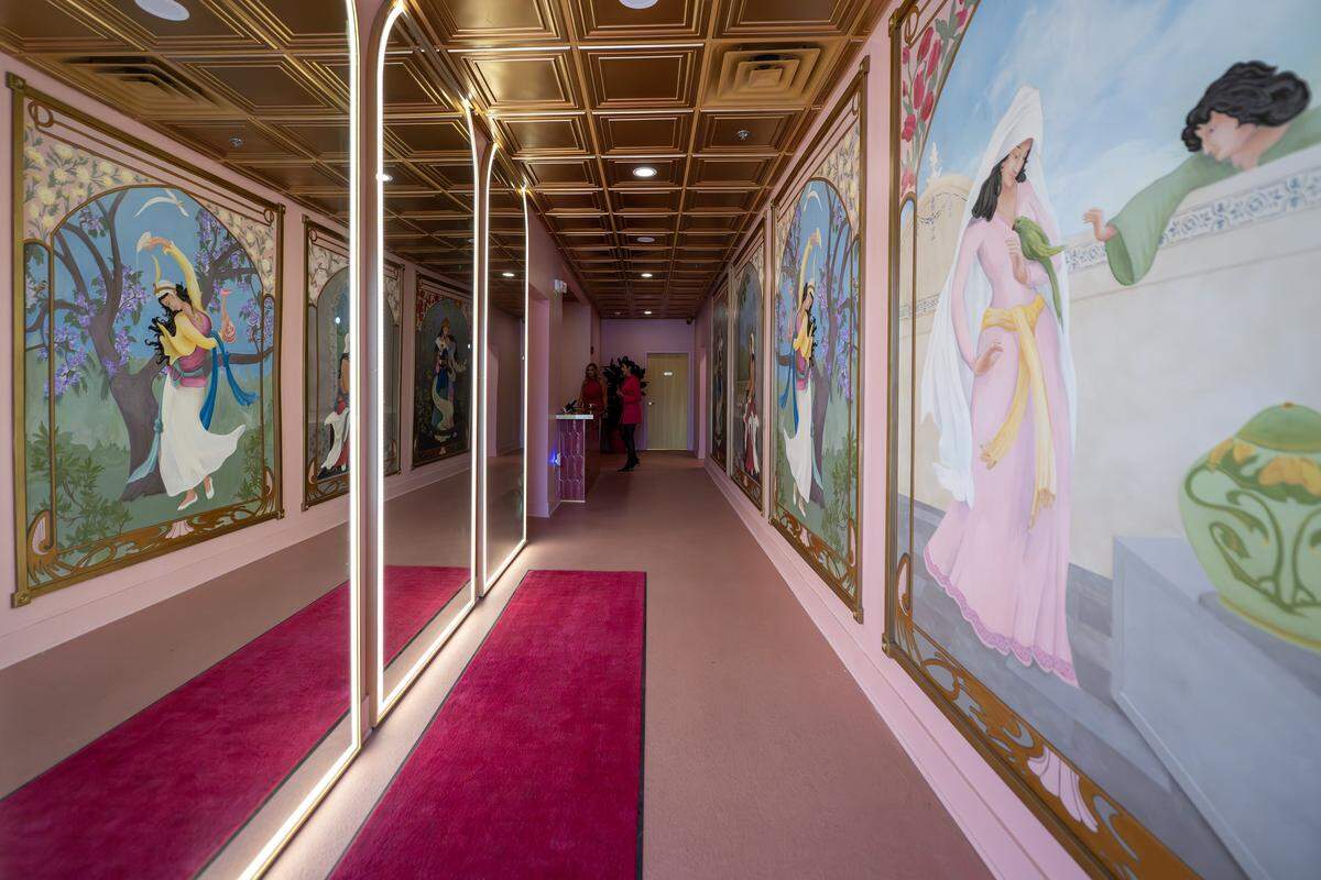 The main entrance hallway to Laila Lounge is adorned with murals, illuminated backlit mirrors, pink floors and gold ceilings, pictured on Friday, Aug. 8, 2025, in Kansas City.