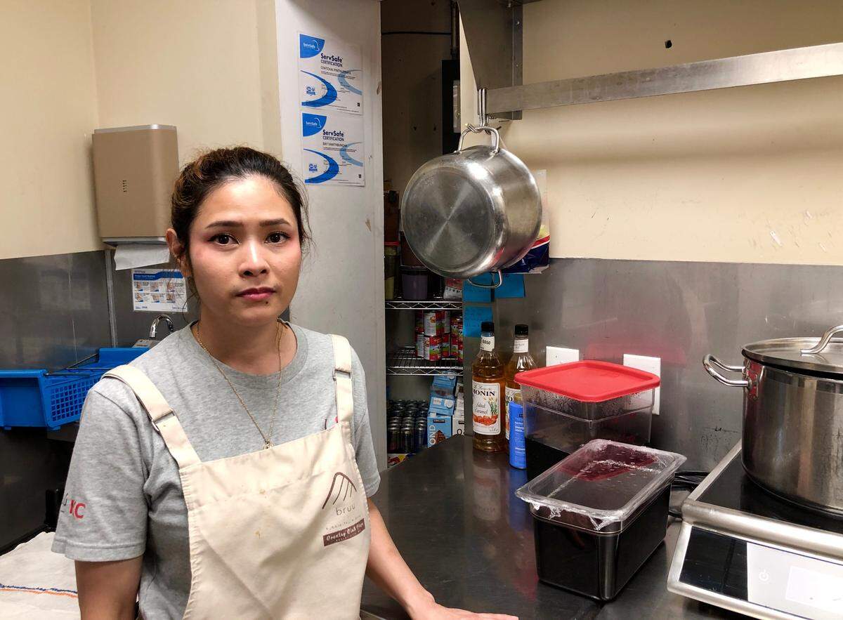 Nycha Sukitti, 31, a manager at Bruú Café Bubble Tea Shop in the Country Club Plaza, stands near a bullet hole in the kitchen, where it landed from a gunshot outside last winter. She wishes for a better Plaza security plan.
