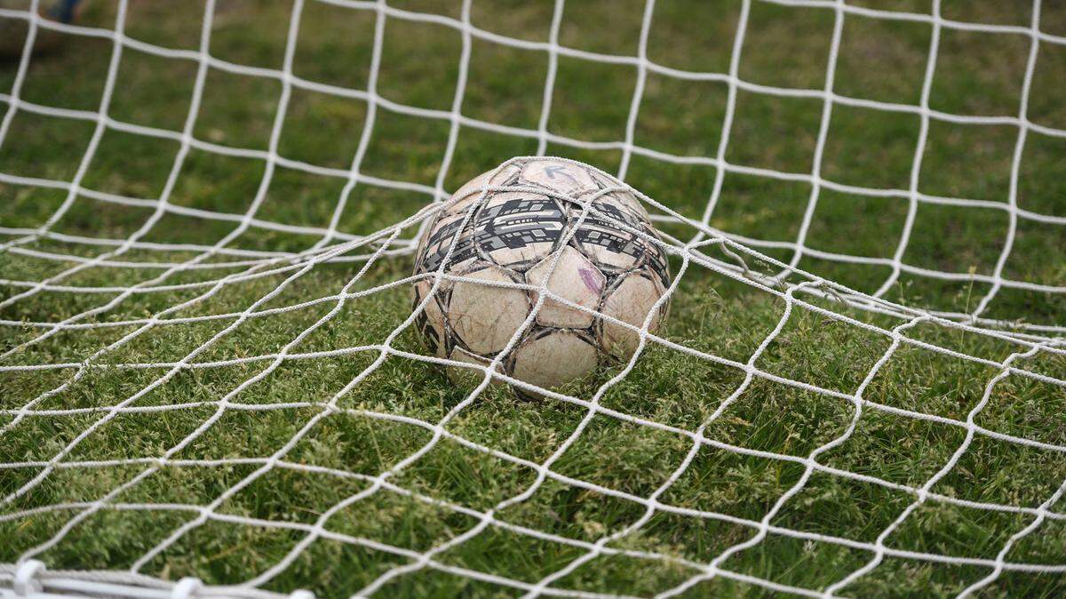A soccer ball sits in the goal.