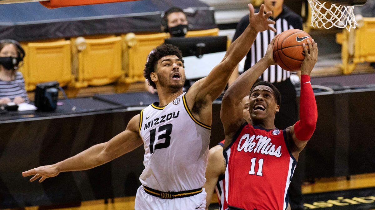 Mississippi’s Matthew Murrell, right, shoots past Missouri’s Mark Smith during the first half of an NCAA college basketball game Tuesday, Feb. 23, 2021, in Columbia, Mo. (AP Photo/L.G. Patterson)