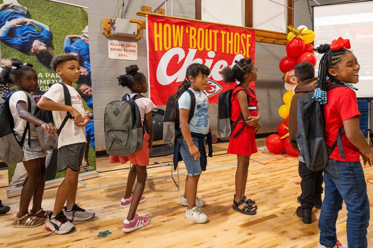 A group of students stand in line to meet Kansas City Chiefs cornerback Trent McDuffie at Gordon Parks Elementary School during a meet & greet and backpack drive on Monday, Aug. 25, 2025, in Kansas City. In addition to signing autographs, McDuffie donated the backpacks, which also included water bottles and school supplies, to 150 kids at the school through his T22 McDuffie Foundation.