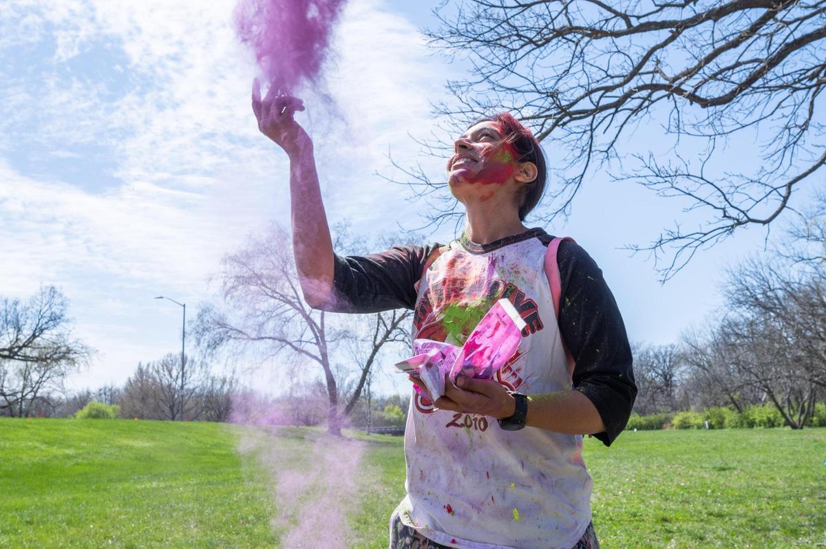 Himani Yadav throws Holi colors into the air at a Holi Festival of Colors in Overland Park on Sunday.