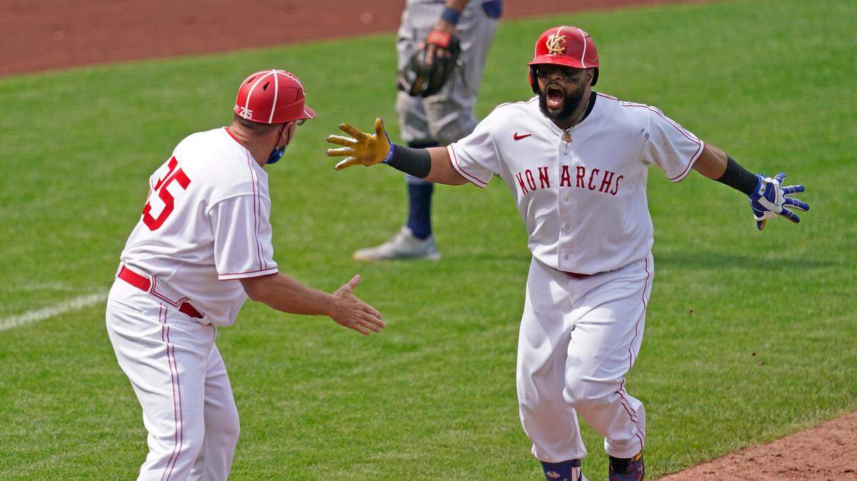 Kansas City Royals’ Carlos Santana celebrates with third base coach Vance Wilson after hitting a walk-off home run during the ninth inning of a baseball game against the Detroit Tigers Sunday, May 23, 2021, in Kansas City, Mo. The Royals won 3-2. (AP Photo/Charlie Riedel)