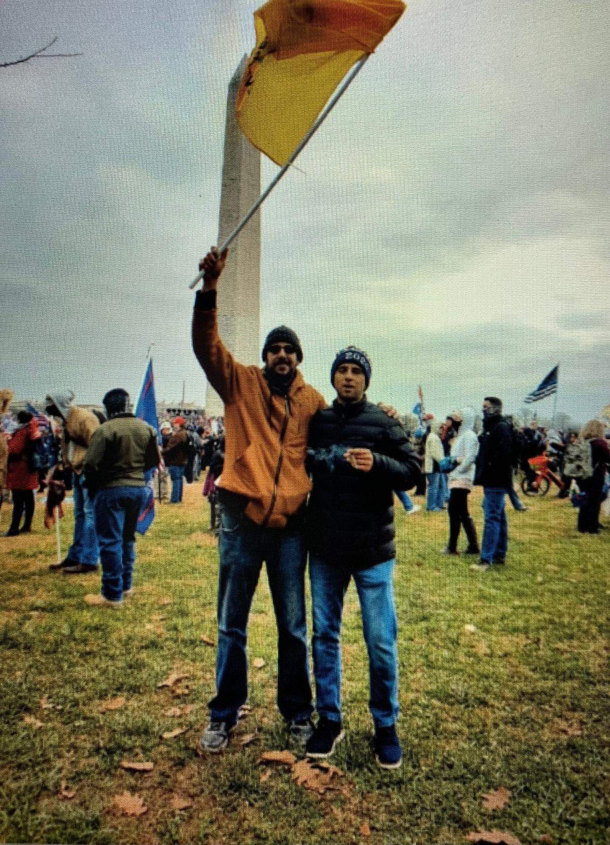 This is a photo Mark Roger Rebegila sent the FBI that shows him, on right, wearing a dark blue jacket and a “Trump 2020” stocking cap, standing near the Washington Monument on Jan. 6.