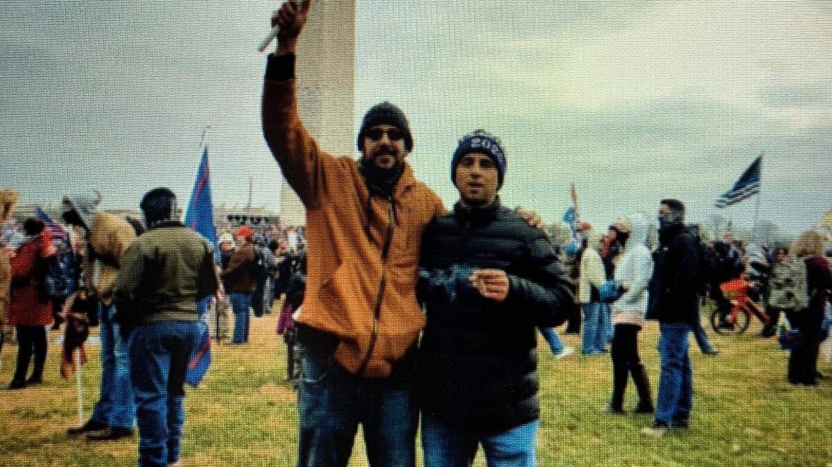 This is a photo Mark Roger Rebegila sent the FBI that shows him, on right, wearing a dark blue jacket and a “Trump 2020” stocking cap, standing near the Washington Monument on Jan. 6.