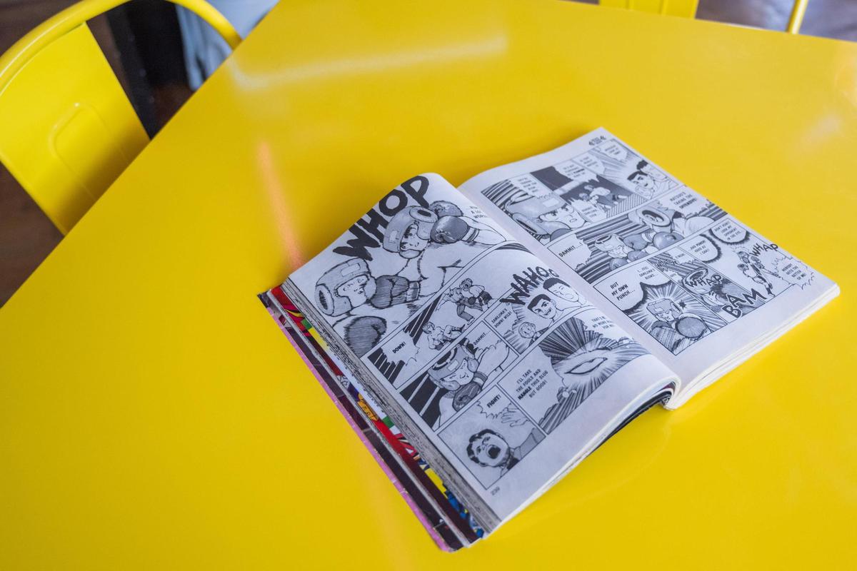 An open manga book rests on a table at Otaku Lounge. Manga is a specific type of Japanese comic book.