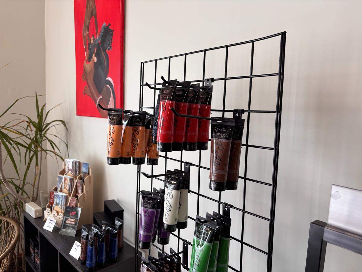 Tubes of Remy Wharry’s Raw Art Paints are displayed for sale inside Raw Art Studio, where visitors can shop art supplies, paint kits and local creative goods.