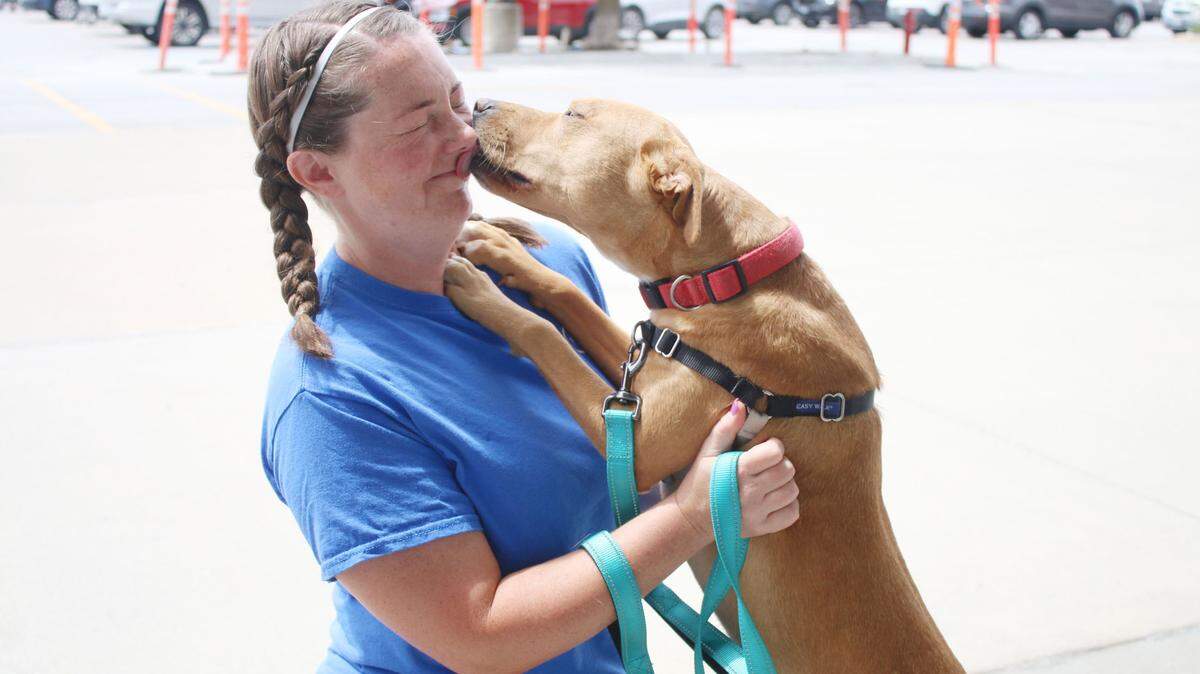 Furry Kids Refuge volunteer Katie Kramer of Lee’s Summit gets a friendly lick from Callie during the weekly adoption event at Petco in Lee’s Summit.