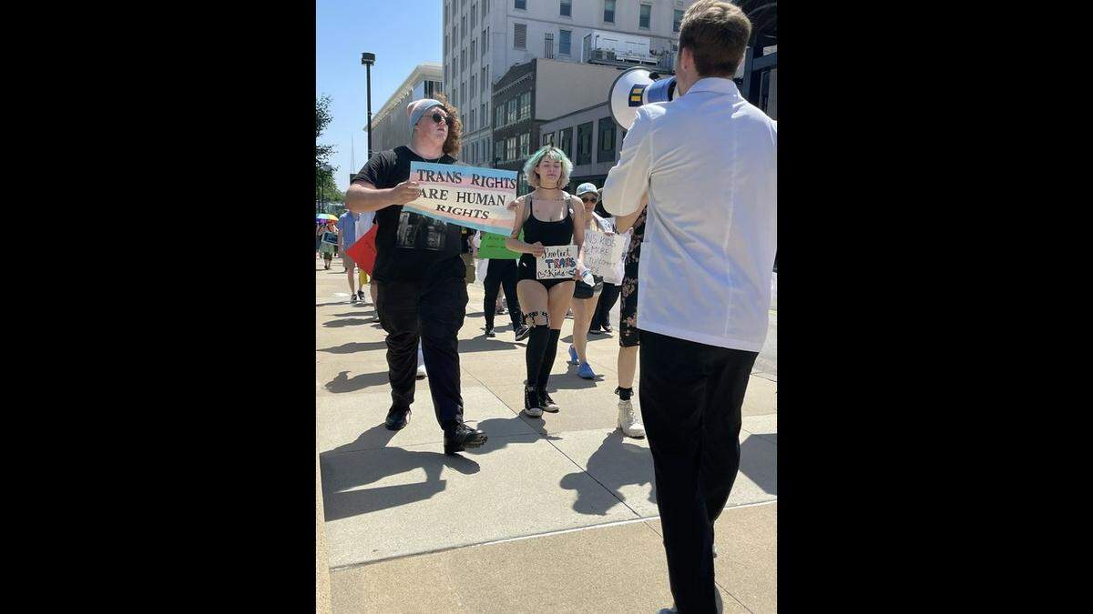 Protesters marched around Ilus Park Saturday afternoon to protest restrictions on gender-affirming care as part of a rally organized by multiple medical students from around the metro area.