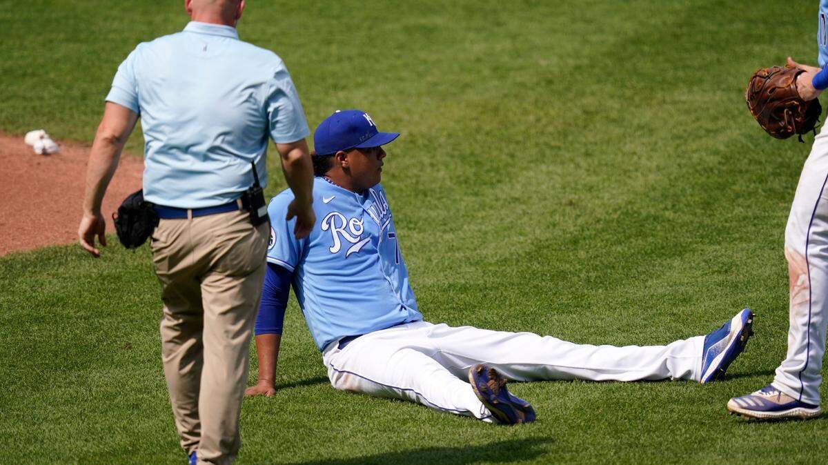 A trainer comes to the aid of Kansas City Royals pitcher Carlos Hernandez (71) after he was hit by a line drive during the sixth inning of a baseball game against the Chicago White Sox at Kauffman Stadium in Kansas City, Mo., Sunday, Sept. 6, 2020.(AP Photo/Orlin Wagner)
