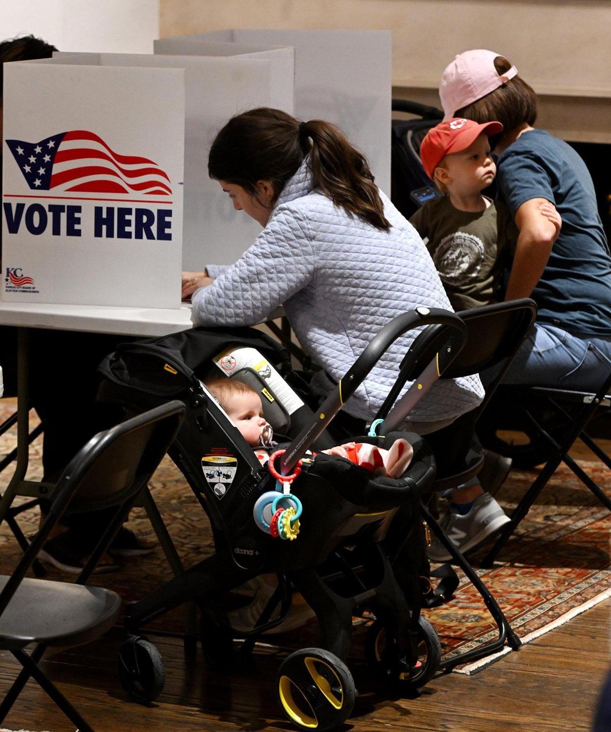 Ellie Logan, left, who was accompanied by her daughter Mary, and Lisa McLaughlin, right, who brought along her son, Brooks, fill out their ballots while voting Tuesday at St. Andrews Episcopal Church, 6401 Wornall Terr., in Kansas City.