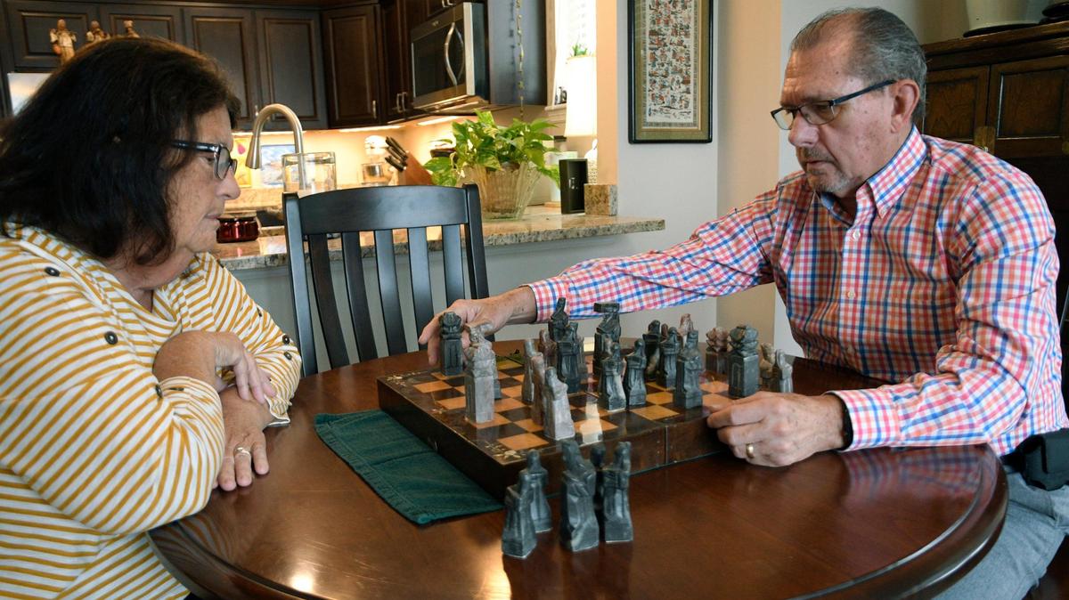Nancy Perry watches as her husband, Robert Perry, 75, concentrates on his next move during a game of chess at their home in Overland Park. Robert Perry recently received a diagnosis of mild cognitive impairment. He has been playing chess and other cognitive, brain-stimulating games to help his memory.