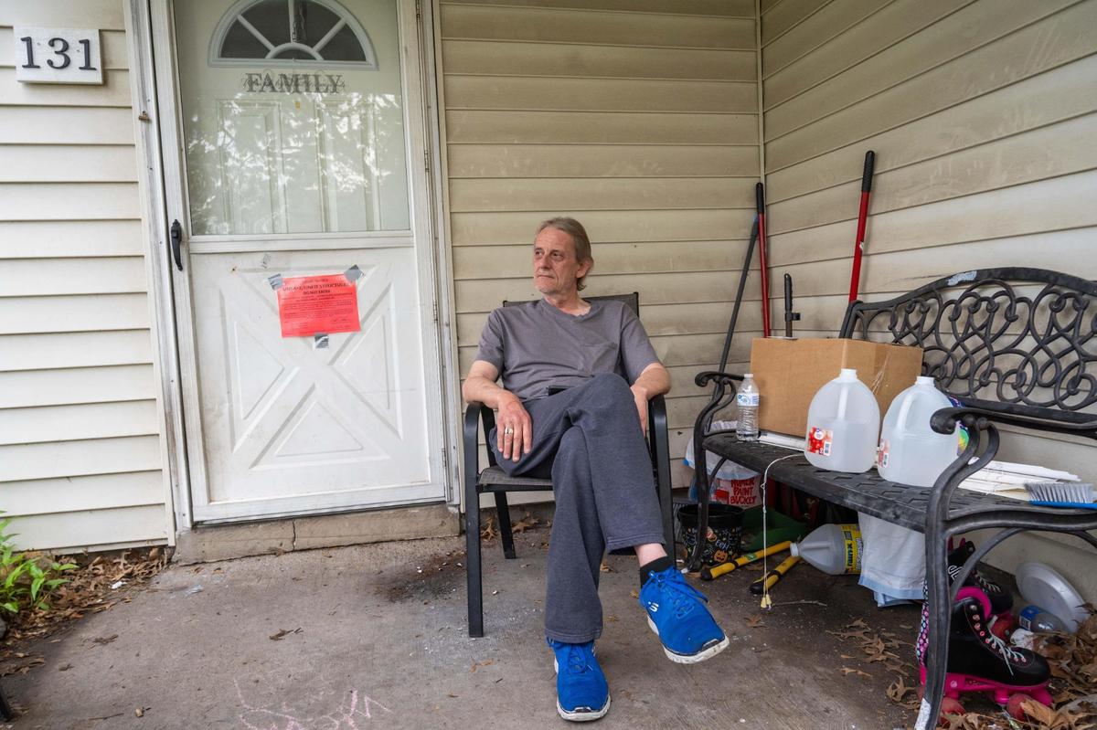 John Leinweber sits on his porch and watches his neighbors move out at Aspen Place Apartments in Gardner on Wednesday, May 7, 2025. Residents were forced to move in 48 hours after the city condemned the entire apartment complex due to several dangerous factors. Leinweber, a 10 year resident, said he was “disappointed, but not surprised.”