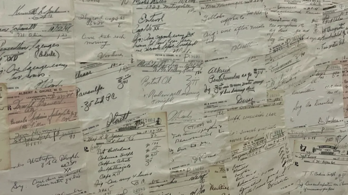 A wall at Pharmington Drugs is plastered with paper prescriptions from an era before patients had drug insurance.