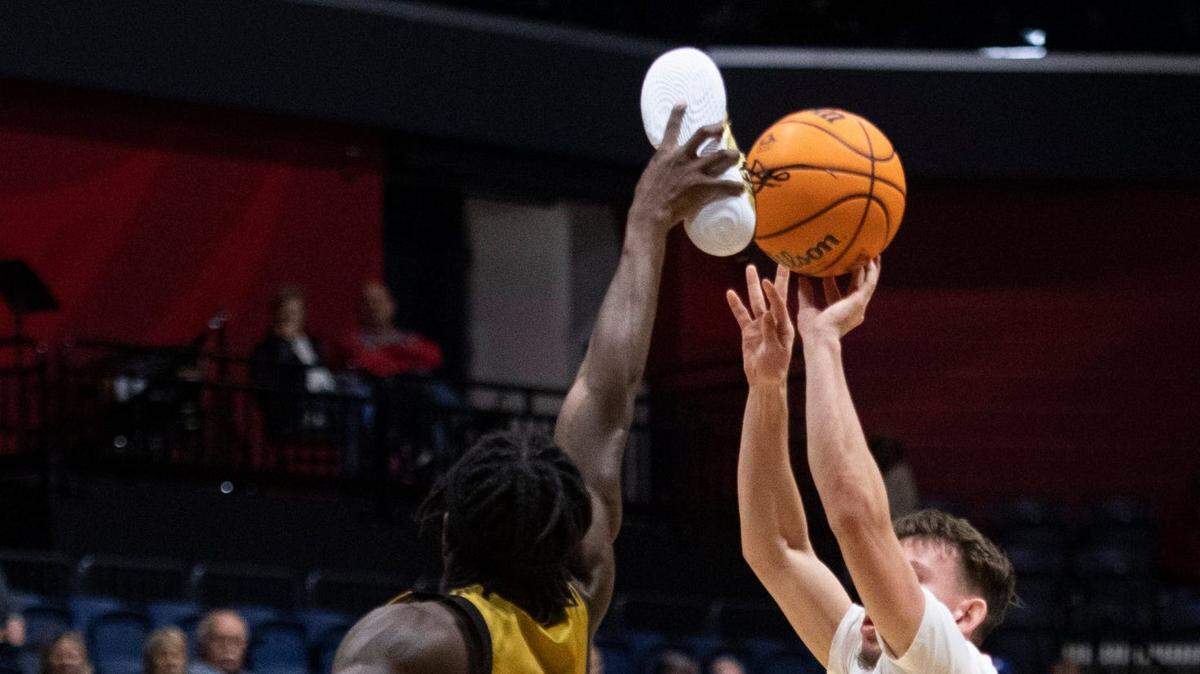 Purdue Fort Wayne’s Rasheed Bello (0) blocks a shot from Southern Indiana’s Jack Campion (5) with his size 12 shoe as the University of Southern Indiana Screaming Eagles play the Purdue Fort Wayne Mastodons at Screaming Eagles Arena in Evansville, Indiana on Wednesday, Dec. 6, 2023.