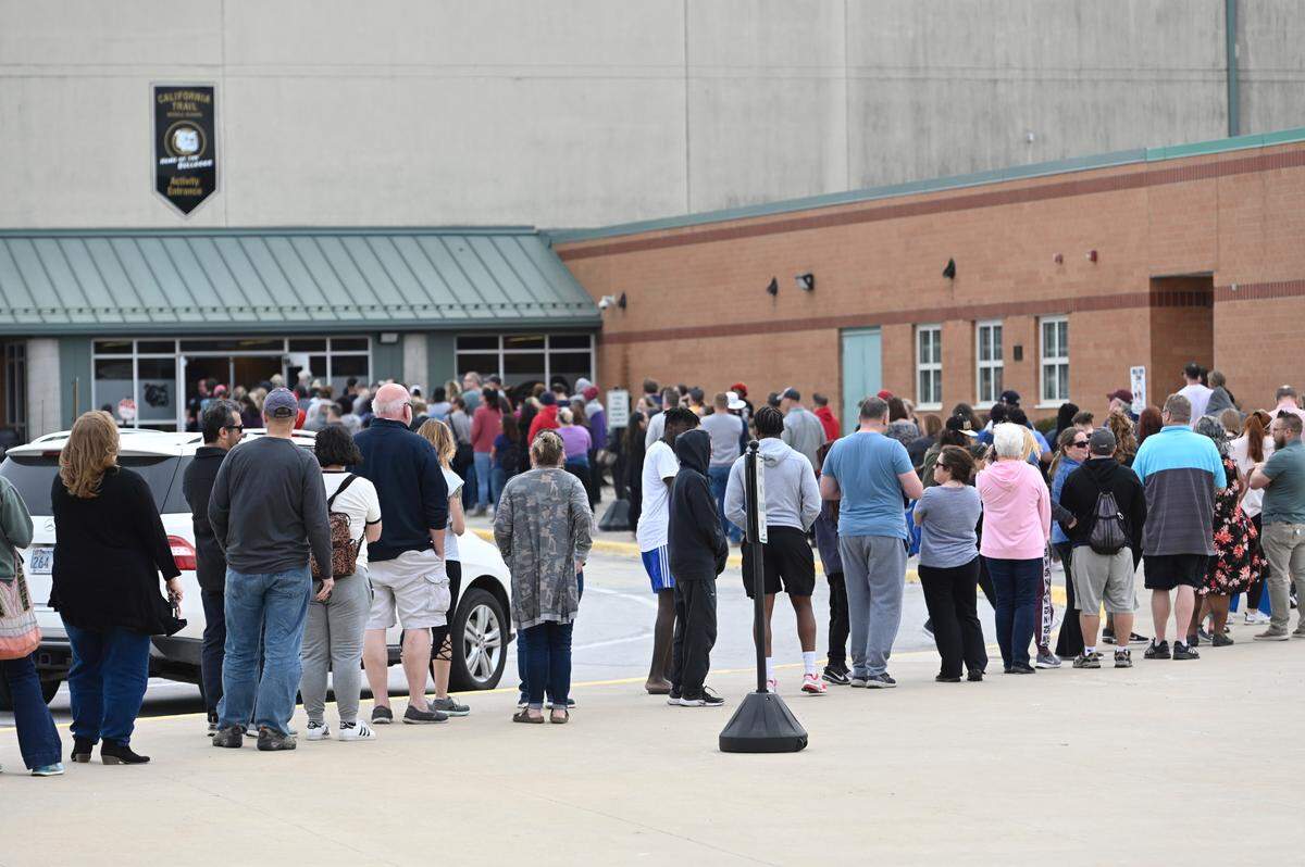 Parents wait outside California Trail Middle School to pick up their Olathe East High School students who were transported there after a shooting at the high school Friday.