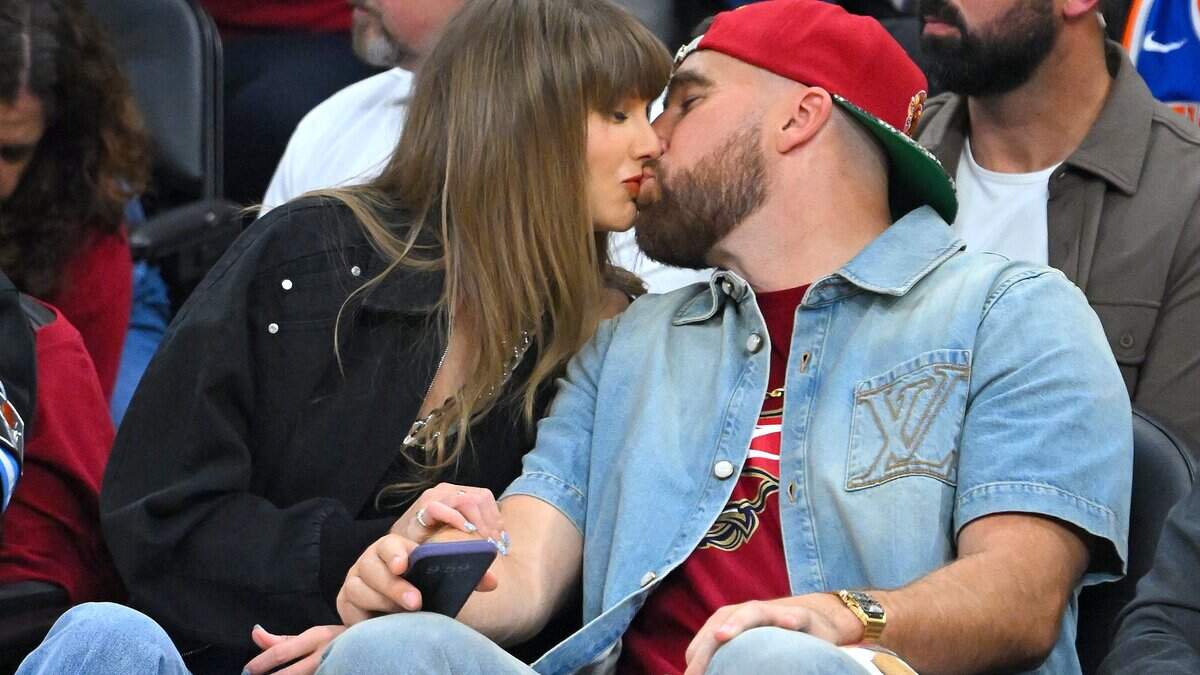 Taylor Swift and Travis Kelce of the Kansas City Chiefs kiss during Game Three between the New York Knicks and the Cleveland Cavaliers in the NBA Eastern Conference Finals at Rocket Arena on May 23, 2026 in Cleveland, Ohio.