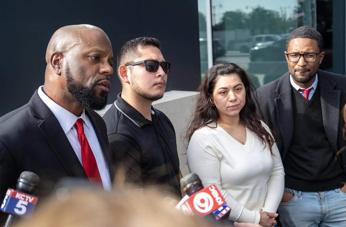 Attorney Thomas Bowers, from left, answers questions as members of Enrique Cartagena-Chacon’s family, Alberto Bernardino and Yeny Cartagena, and lawyer is Quinn Rallins, look on as they addressed the media following a press conference by the Johnson County District Attorney Steve Howe on Thursday, October 9, 2025, in Olathe.  Howe announced the use of force was justified after body camera footage reveals Cartagena-Chacon held a gun and failed to respond to officers' commands. 