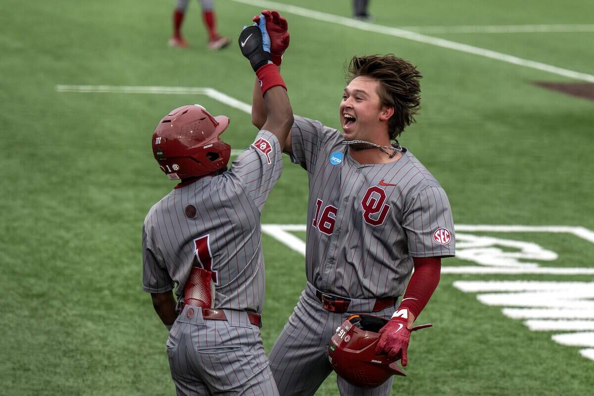 Oklahoma infielder Dayton Tockey (16) celebrates his home run with outfielder Jason Walk (1) during the fourth inning of an NCAA Tournament regional game against Kansas at Hoglund Ballpark on Saturday, June 6, 2026, in Lawrence.