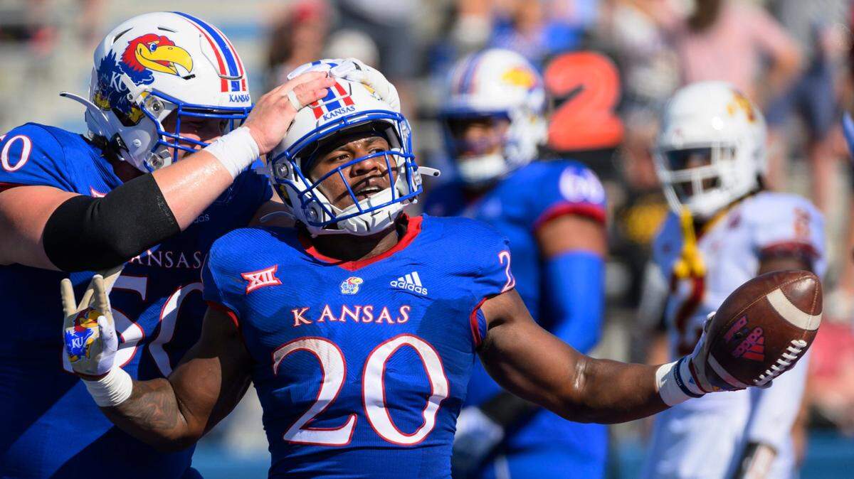 Kansas Jayhawks running back Daniel Hishaw Jr. (No. 20) celebrates with teammate Mike Novitsky (50) after scoring a touchdown against Iowa State on Saturday in Lawrence.
