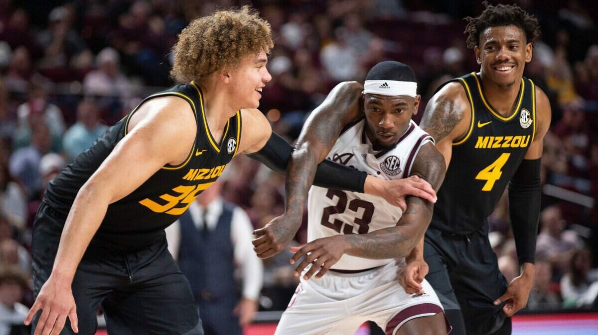 Missouri Tigers forward Noah Carter (35) and guard DeAndre Gholston (4) smile at each other as Texas A&M Aggies guard Tyrece Radford attempts to get past them during a free throw in College Station, Texas, on Jan. 11, 2023.