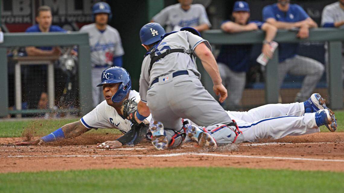 Kansas City Royals catcher Salvador Perez (13) dives home to score a run against Los Angeles Dodgers catcher Will Smith (16) in the first inning at Kauffman Stadium.