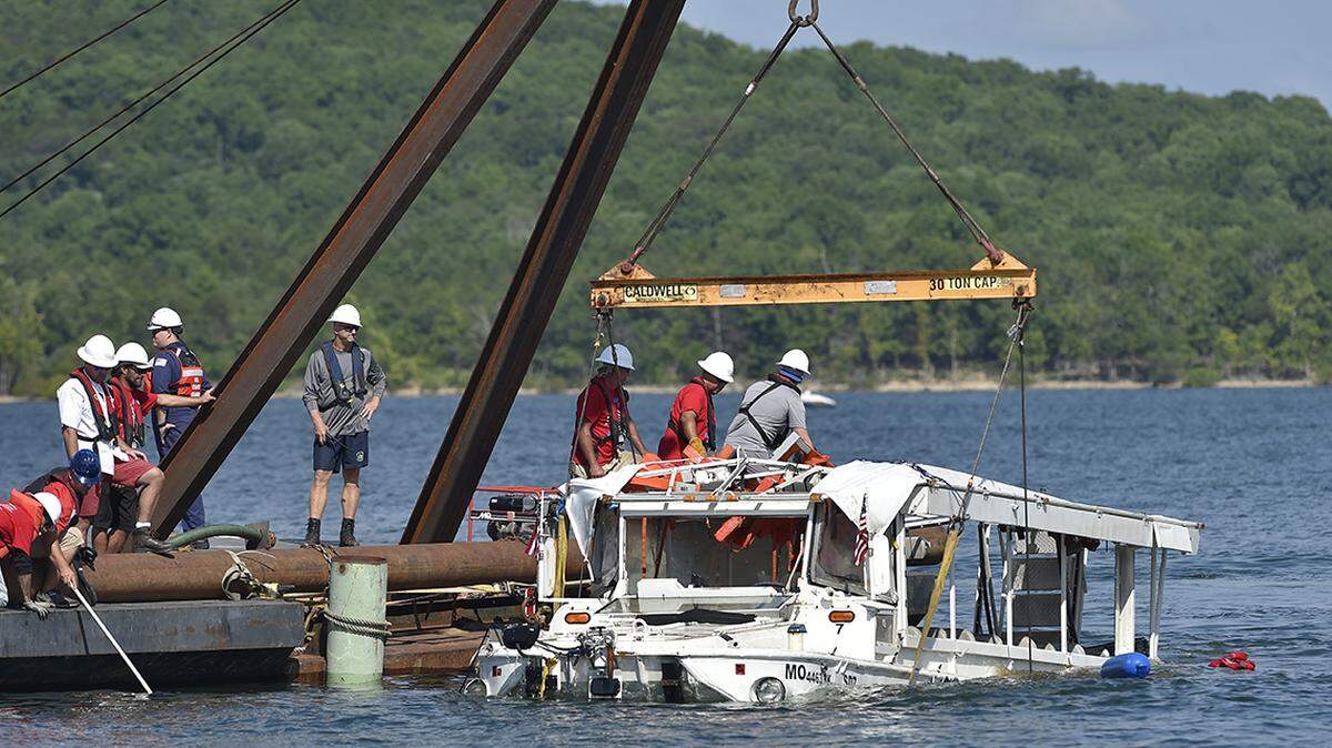 A crew used a barge and a crane to pull a duck boat to the surface Monday, July 23, 2018.  The boat sank in Table Rock Lake near Branson, Missouri, on Thursday, July 19, 2018, killing 17.