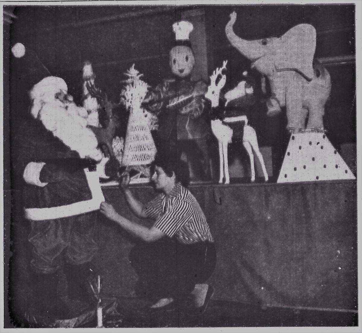 A Harold Gale designer putting the finishing touches on a 6-foot Santa Claus, June 26, 1960.