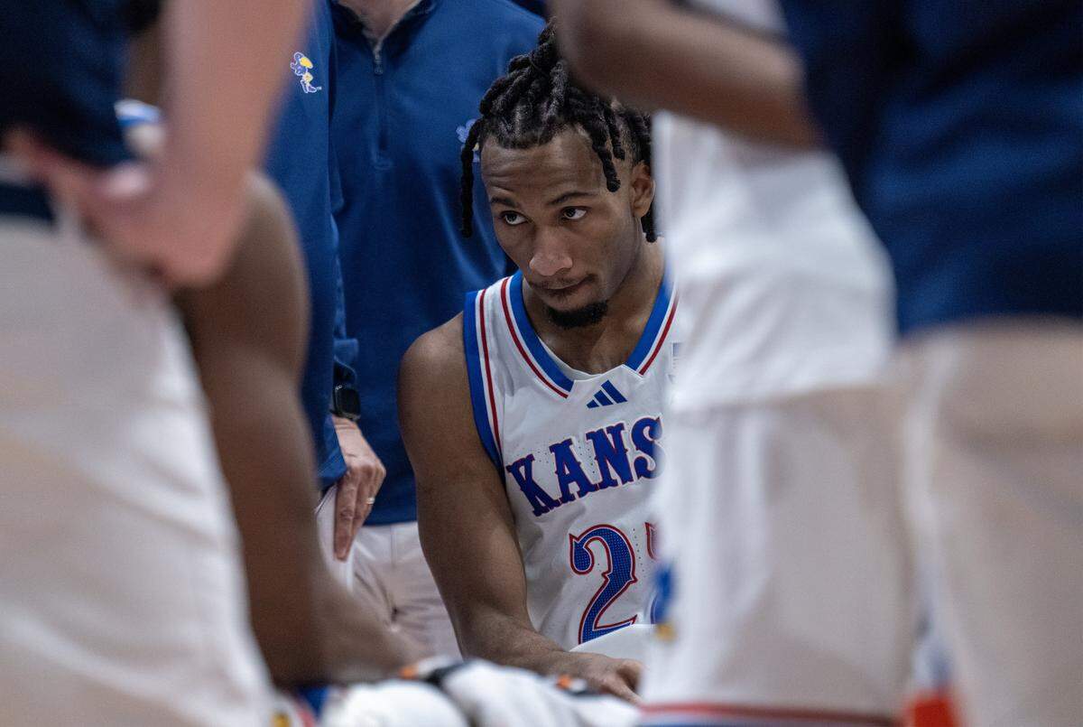 Kansas Jayhawks guard Darryn Peterson (22) sits on the court during a time out as Kansas tries to regroup in second half against the Cincinnati Bearcats at Allen Fieldhouse on Saturday, Feb. 21, 2026, in Lawrence, Kansas.