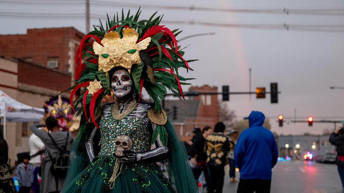 A woman dressed as a Catrina walks along Central Avenue during the Dia de los Muertos event hosted by the Central Avenue Betterment Association on Saturday in Kansas City, Kan.