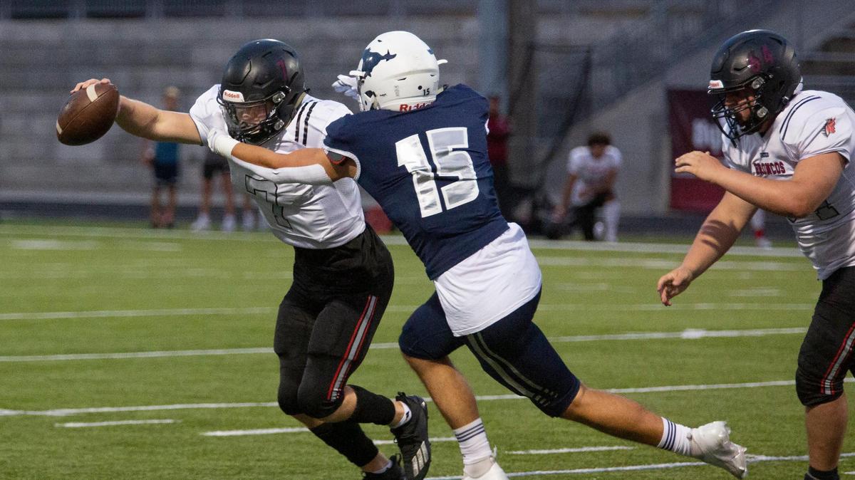 Lee’s Summit North’s quarterback, #7,Tre Baker tried to get past Adam Parks, #15 of Blue Valley North, Friday, Sept. 24, 2021 during the game at Blue Valley North.